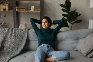 Smiling attractive young woman leaning back on cozy couch