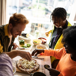 Friends making pizza at home CANVA