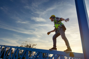 Engineer technician worker working in a metal roof structure of