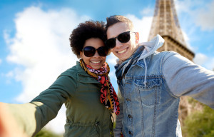happy couple taking selfie over eiffel tower