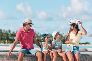 Family with two kids play run on tropical beach