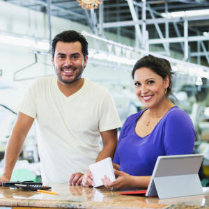 Hispanic small business owners, dry cleaner paying bills CANVA