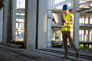 Picture of construction site engineer looking at plan