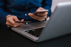 Female hands holding a credit card and using laptop for online s