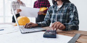 Architect and Engineer working with blueprints for architectural plan, engineer sketching a construction project, green energy concept