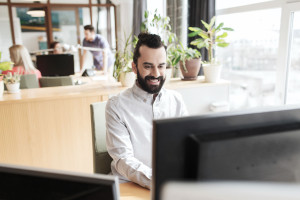 happy creative male office worker with computer