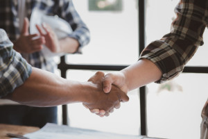 Team engineers and architects shake hands with the condo project