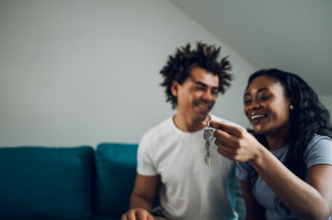 African american couple holding home keys in their new apartment