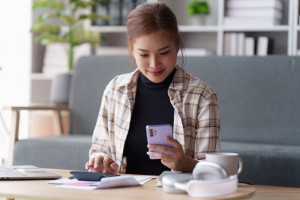 Asian accounting professional calculating household bills, reviewing and analyzing household bills, and filing tax returns.