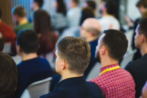 Conference participants, events, presentations, listen to the speaker sitting in chairs.