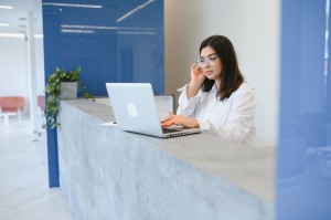 Young female receptionist working in office