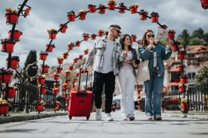 Group of friends traveling together, exploring city sights with map and luggage in spring