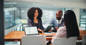 People, explain and meeting on tablet in office for feedback, finance results and budget review. Staff, team and graph on PC with financial report, profit growth and revenue update of risk assessment