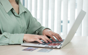 The businesswoman's hand is holding a credit card and using a la