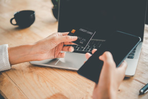 Women's hands holding a credit card and work on laptop Online pa