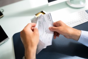 189908991 - holding paycheck or payroll check. insurance payment